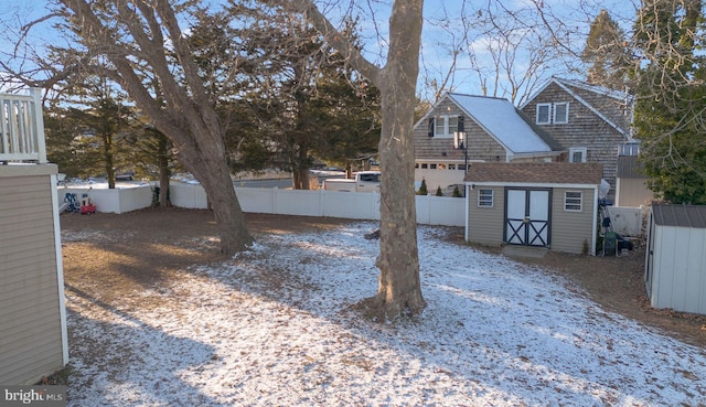 yard covered in snow featuring a storage unit