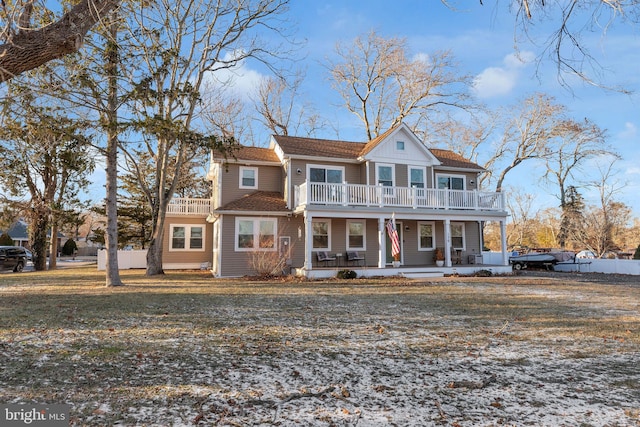 view of front of home featuring a balcony, covered porch, and a front lawn