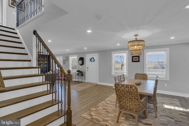 dining room featuring crown molding, wood-type flooring, and a notable chandelier