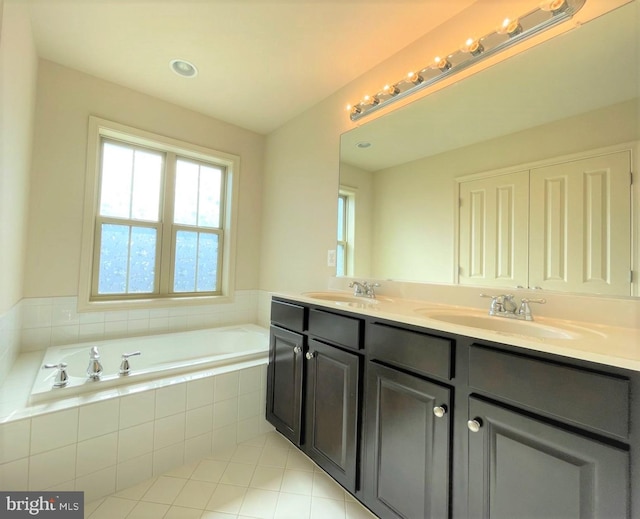 bathroom featuring tiled tub and vanity