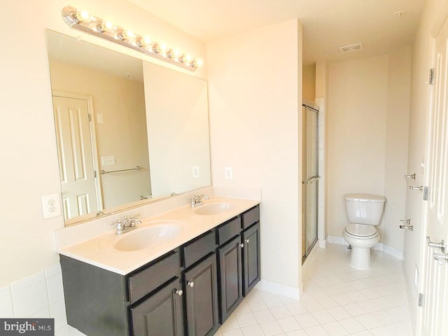 bathroom with tile patterned flooring, vanity, a shower with door, and toilet