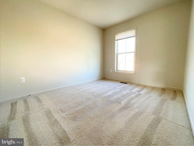 spare room featuring light colored carpet