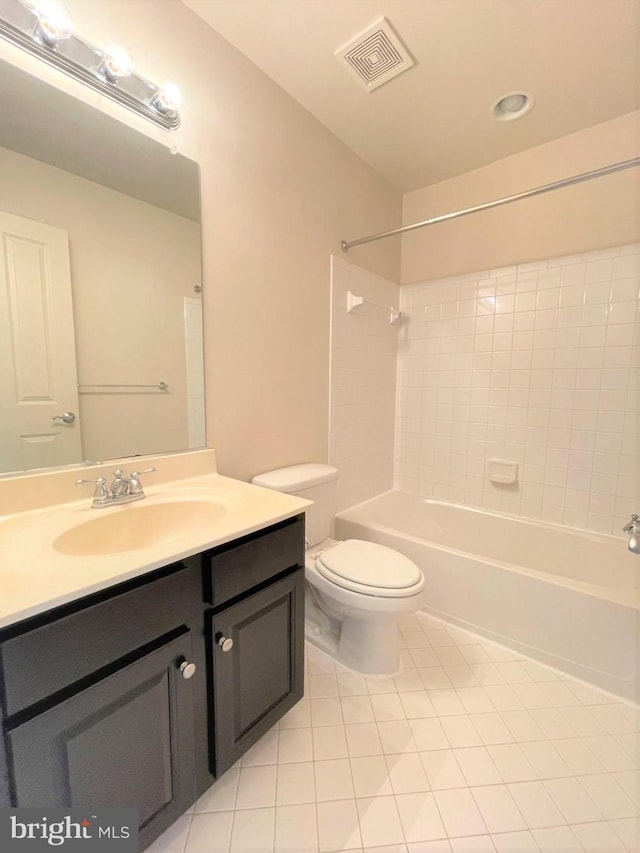 full bathroom with vanity, tiled shower / bath combo, tile patterned floors, and toilet