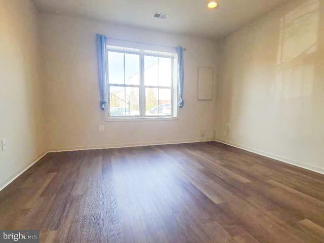 unfurnished room with dark wood-type flooring