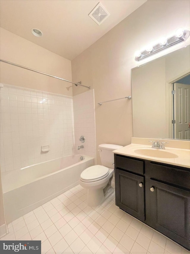 full bathroom with tiled shower / bath combo, vanity, tile patterned floors, and toilet