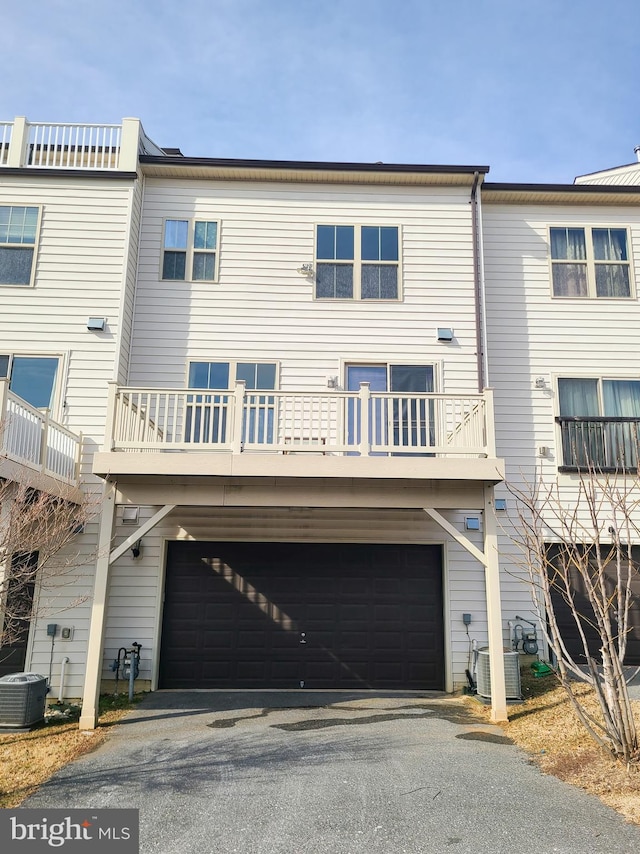 back of property featuring central AC unit and a garage