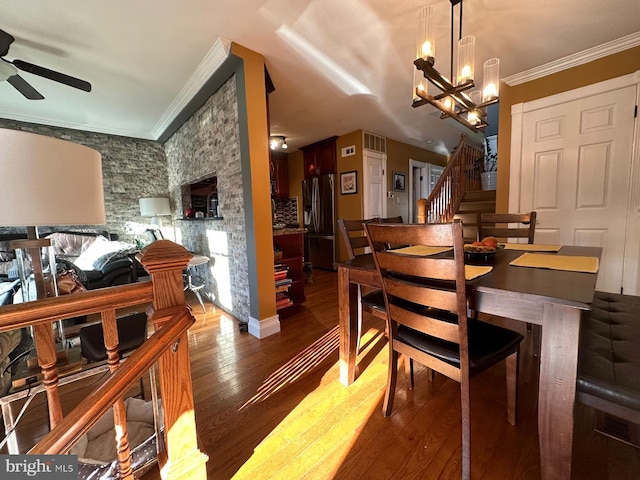 dining room featuring hardwood / wood-style flooring, ornamental molding, and ceiling fan with notable chandelier