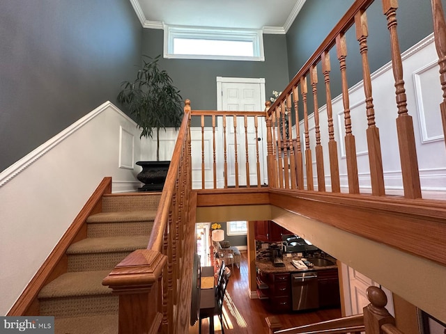 stairs with hardwood / wood-style flooring and ornamental molding