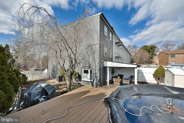 wooden terrace featuring grilling area and an outdoor structure