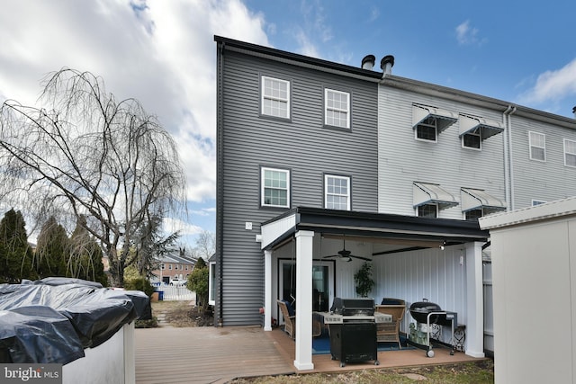 back of house with a deck and ceiling fan