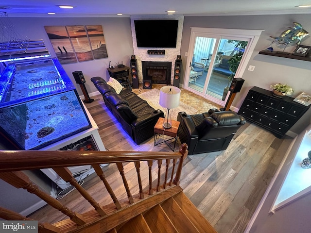 living room featuring crown molding, hardwood / wood-style flooring, and a fireplace