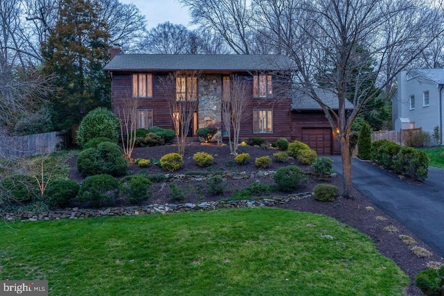 view of front of property with a garage and a front lawn