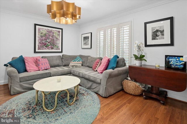 living room with crown molding, hardwood / wood-style floors, and an inviting chandelier