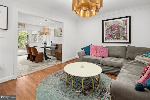 living room featuring crown molding, hardwood / wood-style flooring, and a chandelier