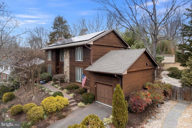 view of front of home featuring a garage and solar panels