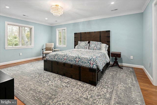 bedroom with crown molding, wood-type flooring, and multiple windows