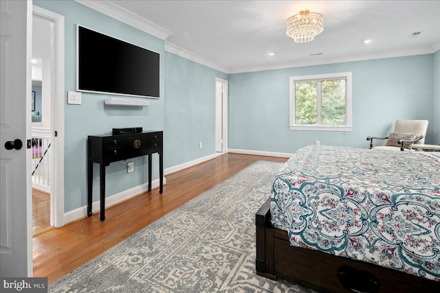 bedroom featuring crown molding, a chandelier, and hardwood / wood-style flooring