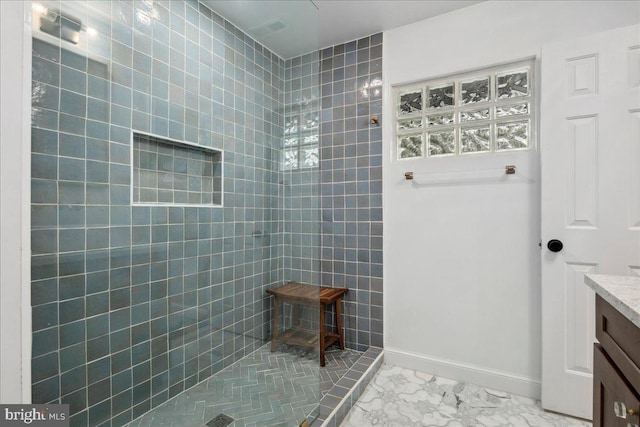 bathroom featuring vanity and a tile shower