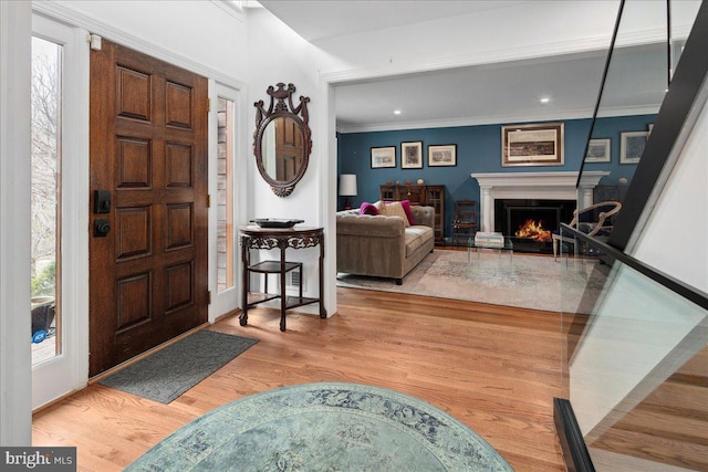 foyer entrance with wood-type flooring and crown molding