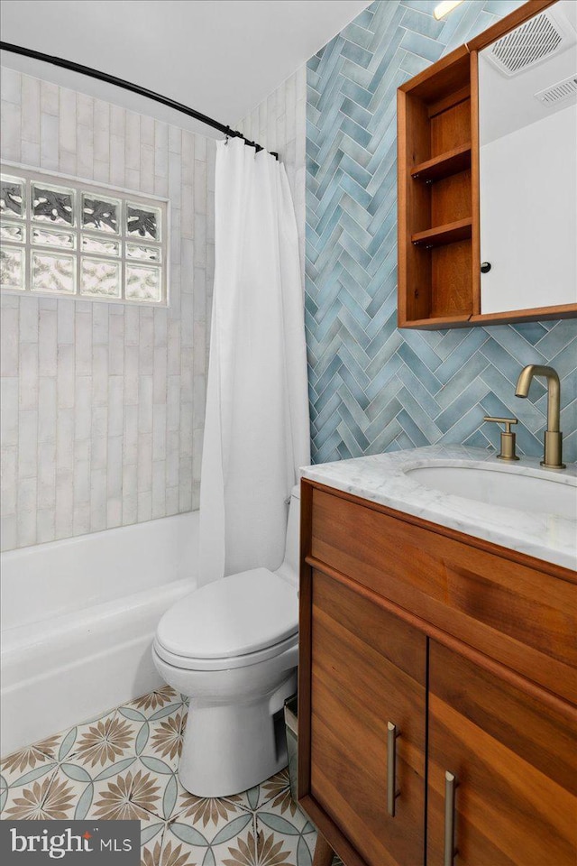 full bathroom with tile walls, vanity, shower / tub combo, toilet, and tile patterned floors