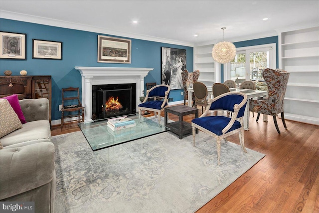 living room featuring crown molding, wood-type flooring, and built in shelves