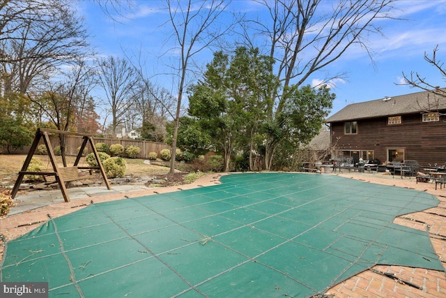 view of swimming pool featuring a playground and a patio area