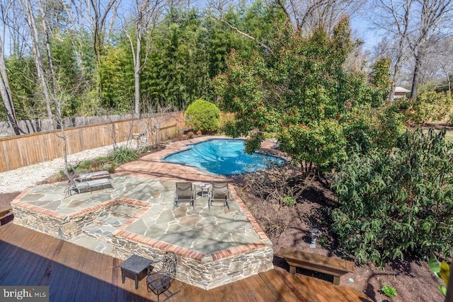 view of pool with a wooden deck and a patio area