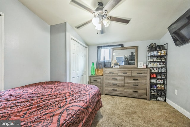 bedroom featuring vaulted ceiling, light colored carpet, a closet, and ceiling fan