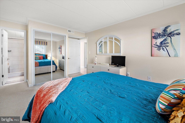 bedroom featuring crown molding, ensuite bathroom, and a closet