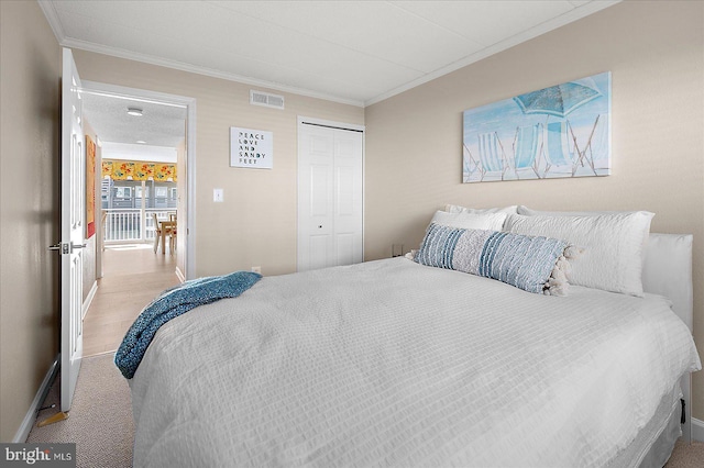 bedroom with crown molding, light colored carpet, and a closet