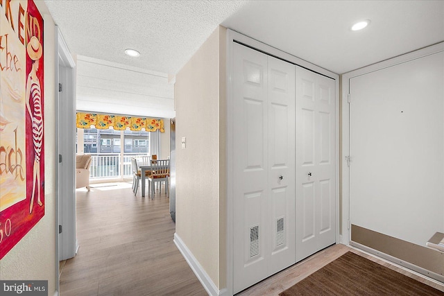 corridor featuring hardwood / wood-style floors and a textured ceiling