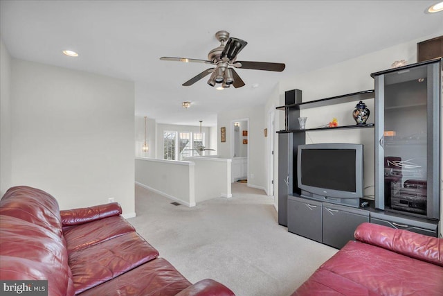 carpeted living room with ceiling fan