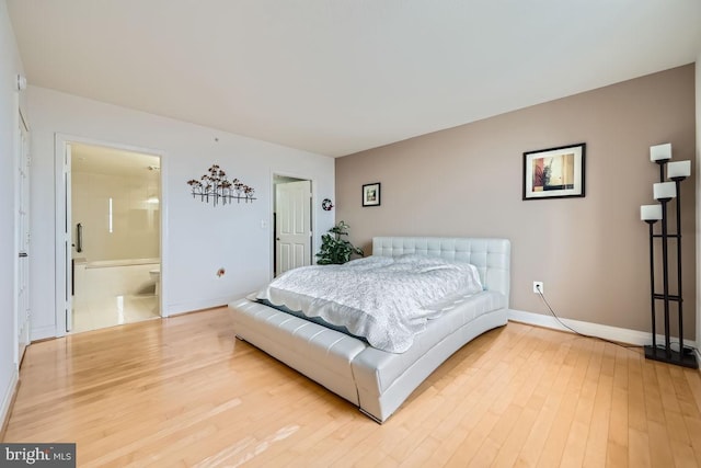 bedroom featuring connected bathroom and hardwood / wood-style floors