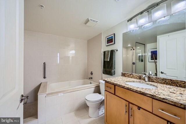 full bathroom with vanity, tiled shower / bath, tile patterned floors, and toilet