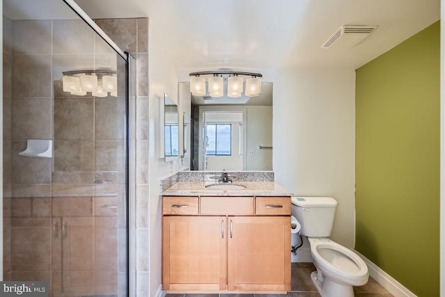 bathroom featuring vanity, a shower with shower door, and toilet