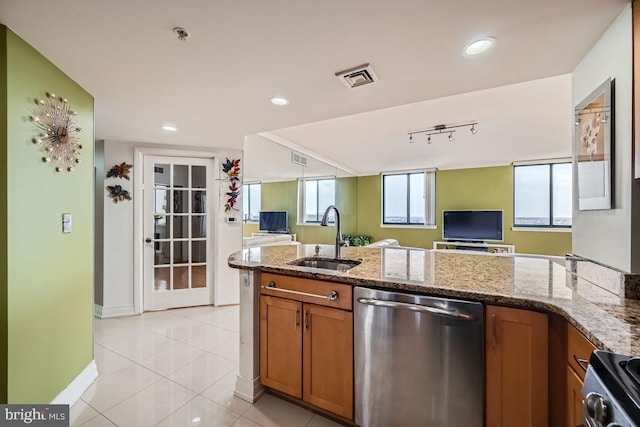 kitchen with stone countertops, sink, stove, stainless steel dishwasher, and light tile patterned floors