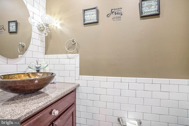 bathroom with vanity and tile walls