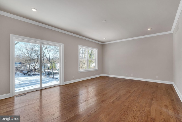 empty room featuring hardwood / wood-style flooring and ornamental molding