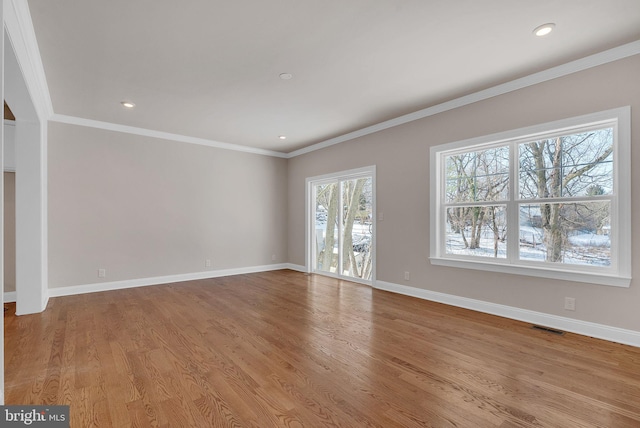 unfurnished room featuring ornamental molding and light wood-type flooring