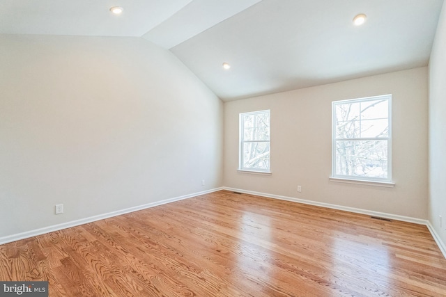 empty room featuring lofted ceiling and light wood-type flooring