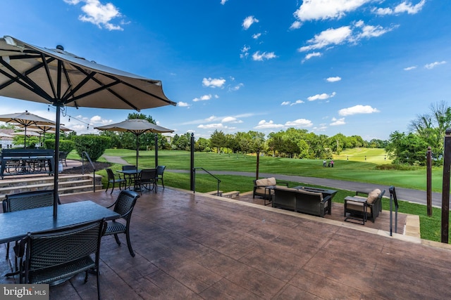 view of patio / terrace with golf course view, a fire pit, and outdoor dining area