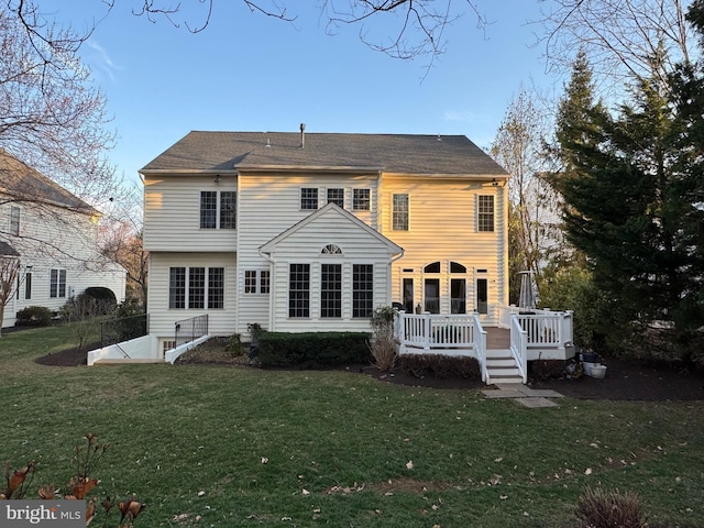 rear view of house featuring a yard and a wooden deck