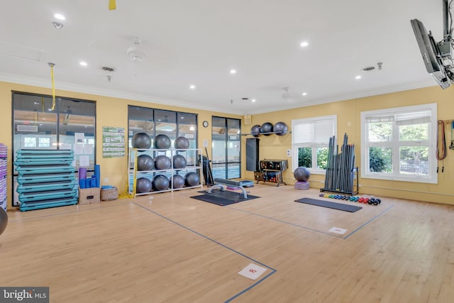 exercise room with recessed lighting, wood finished floors, and crown molding