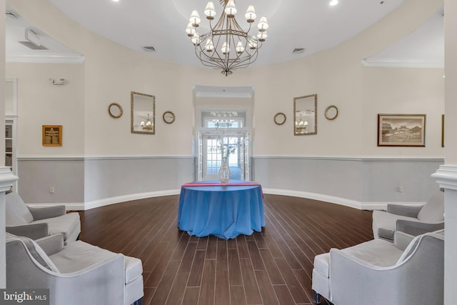 living area featuring visible vents, baseboards, a notable chandelier, and wood finished floors