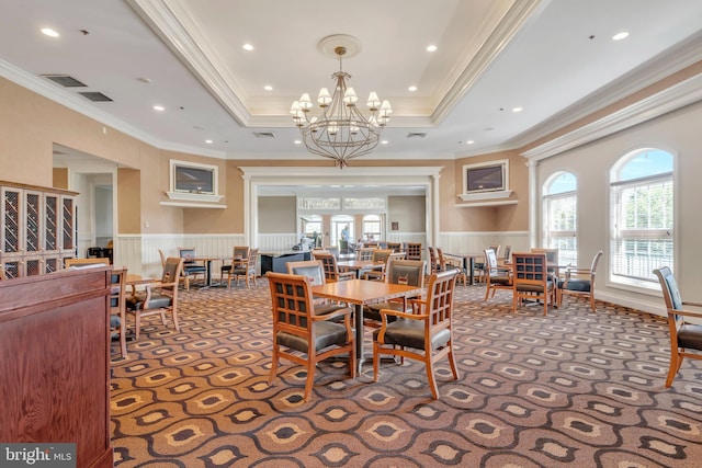 dining area featuring visible vents, carpet floors, a raised ceiling, and wainscoting