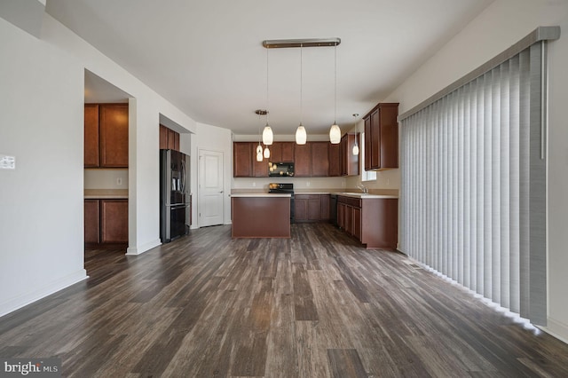 kitchen featuring electric stove, stainless steel fridge, hanging light fixtures, dark hardwood / wood-style floors, and a center island