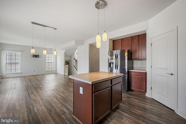 kitchen with stainless steel refrigerator with ice dispenser, a kitchen island, dark wood-type flooring, and pendant lighting