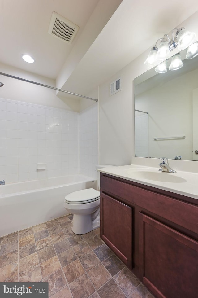 full bathroom with vanity, tiled shower / bath, and toilet