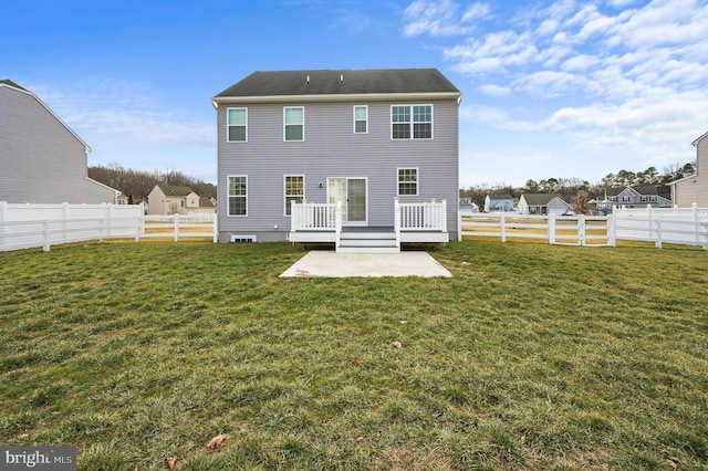 back of house featuring a wooden deck, a patio, and a lawn