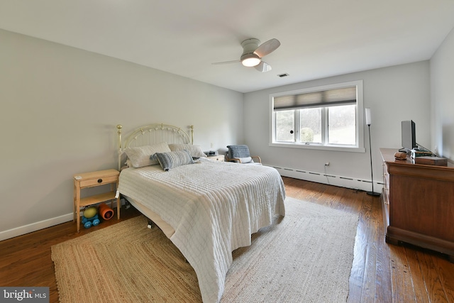 bedroom featuring ceiling fan, a baseboard heating unit, and dark hardwood / wood-style floors